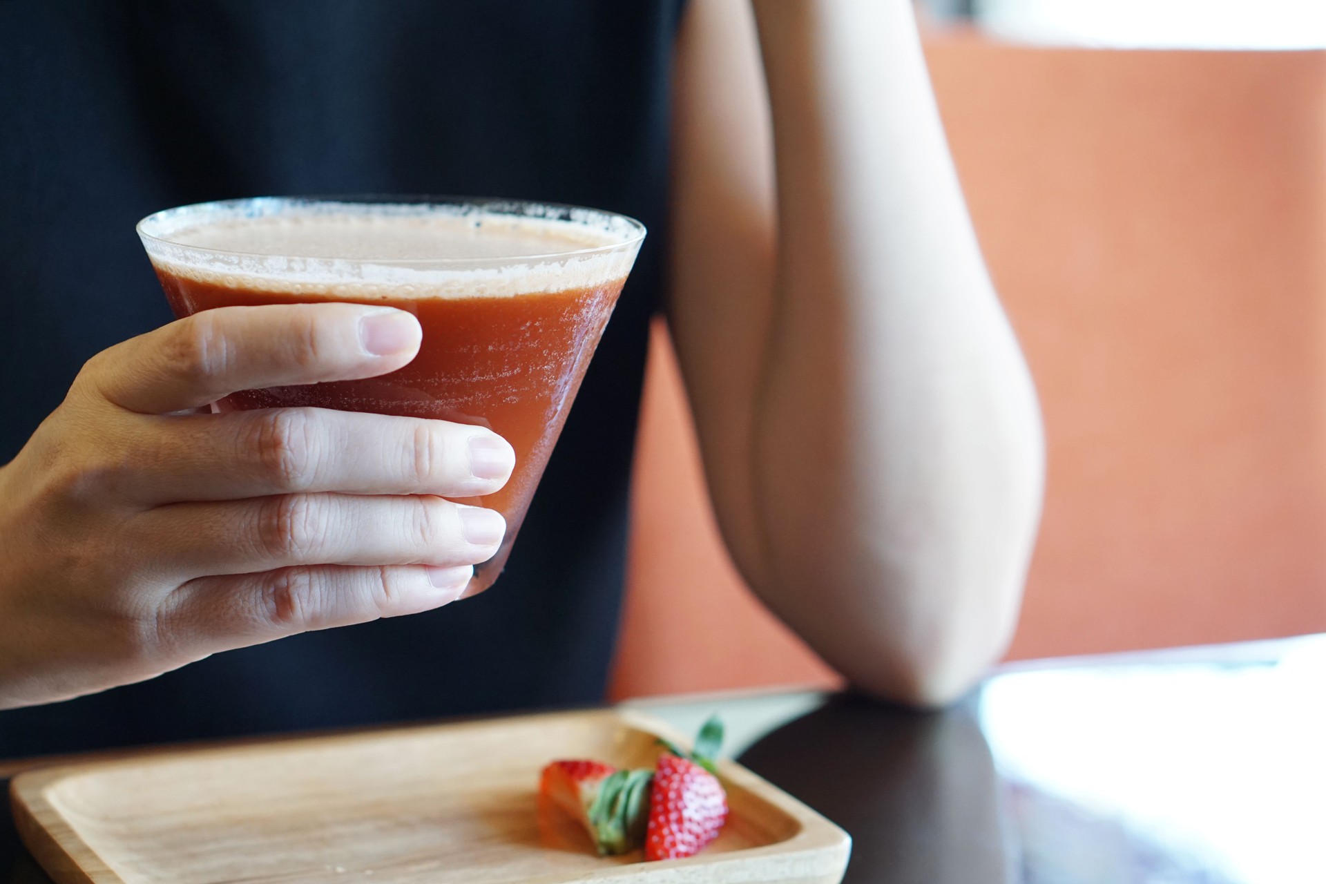 Closeup glass of Iced coffee with strawberry syrup, mango syrup and soda on wooden tray.