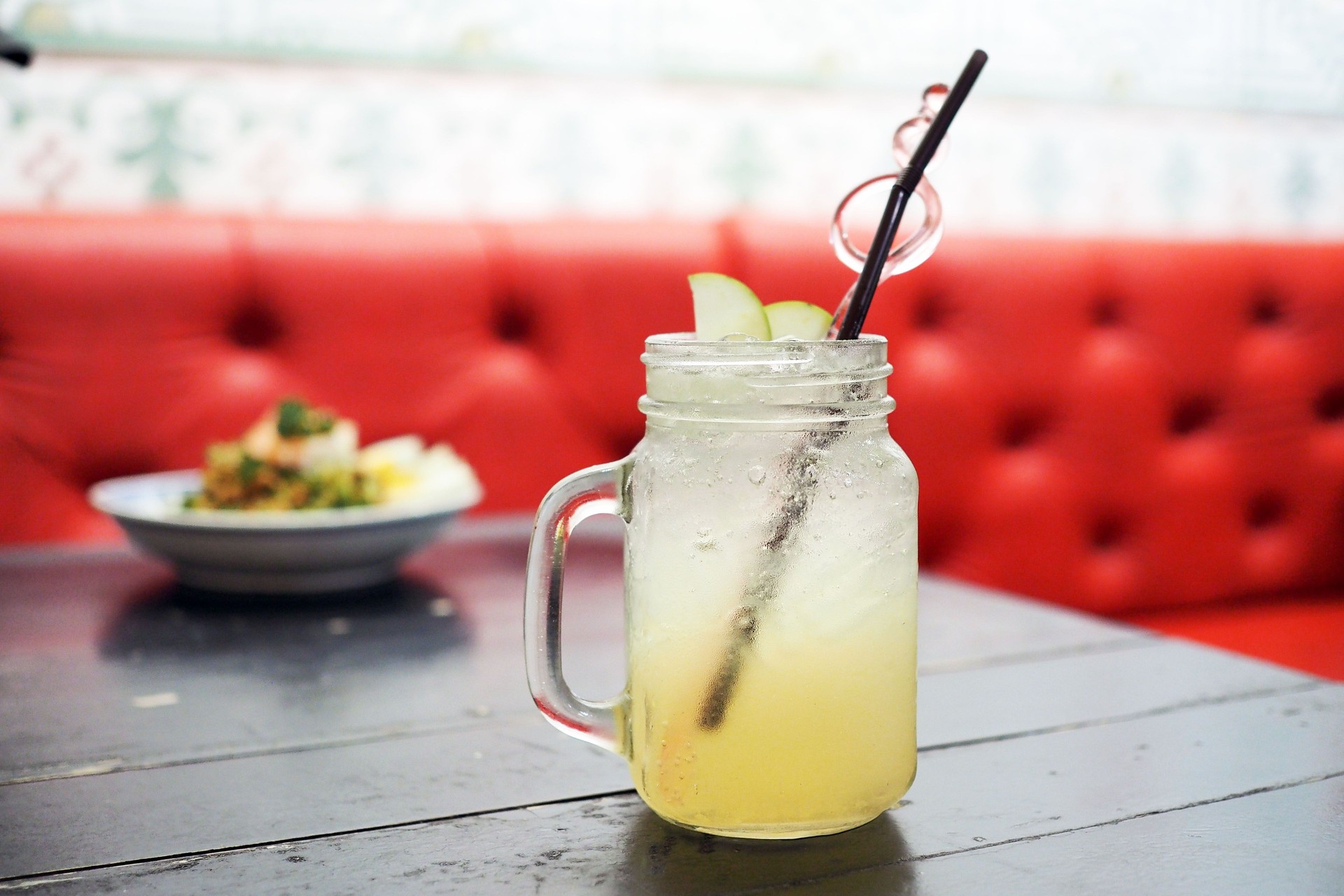 A glass of iced honey lemon with sparkling soda on wooden table.