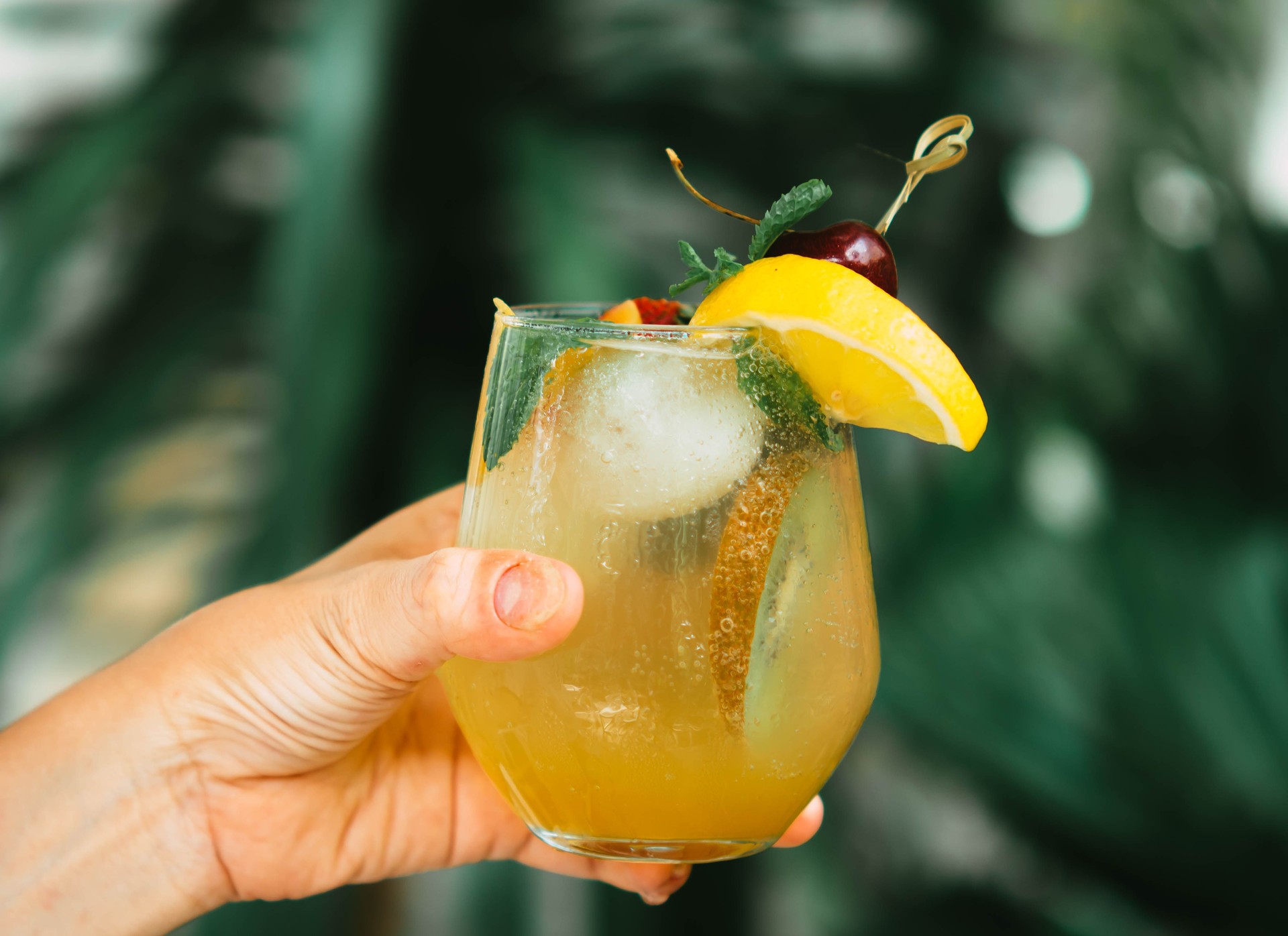 hand hold mock tail or cocktail with green nature background