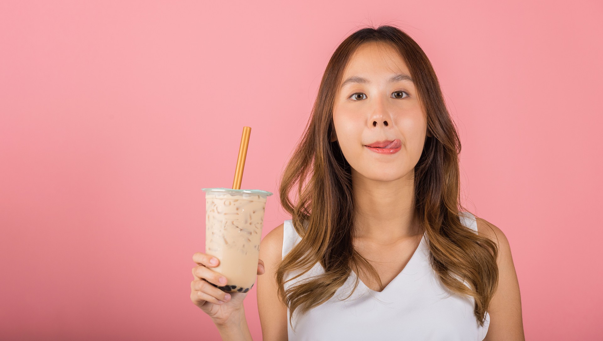 woman holding drinking brown sugar flavored tapioca pearl bubble milk tea lick lips wanna taste