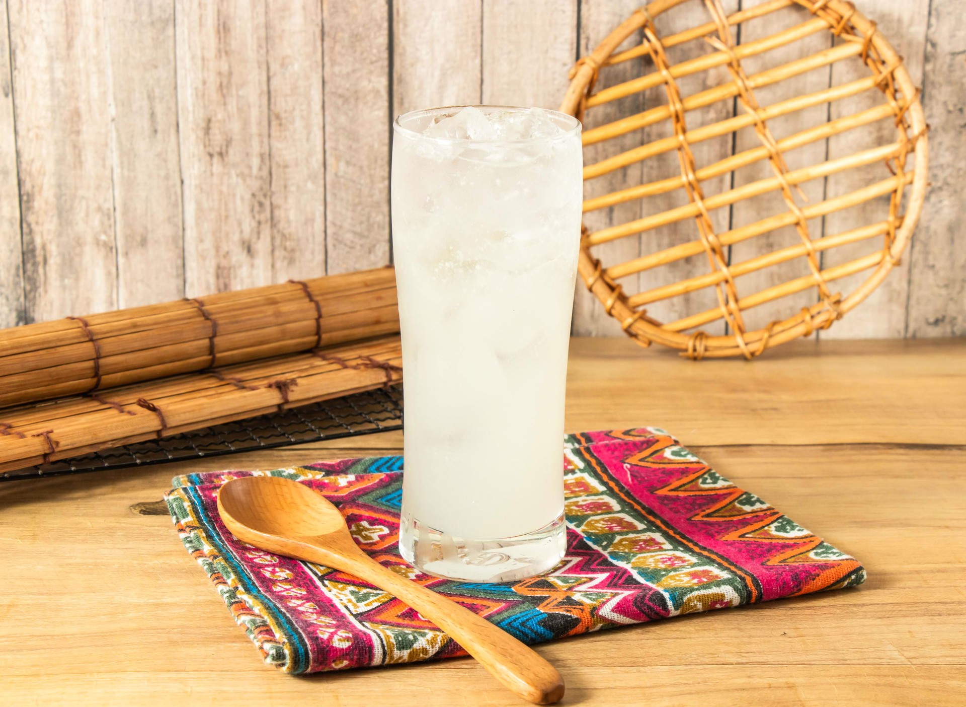 Refreshing Iced Lemonade, Lemon plum or lemon soda filled with ice cubes served in tall glass isolated on napkin side view on wooden table of taiwan drink